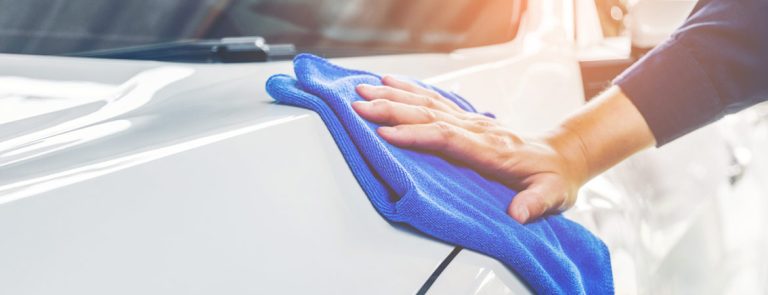 Lackpflege eines Autos mit blauem Lappen