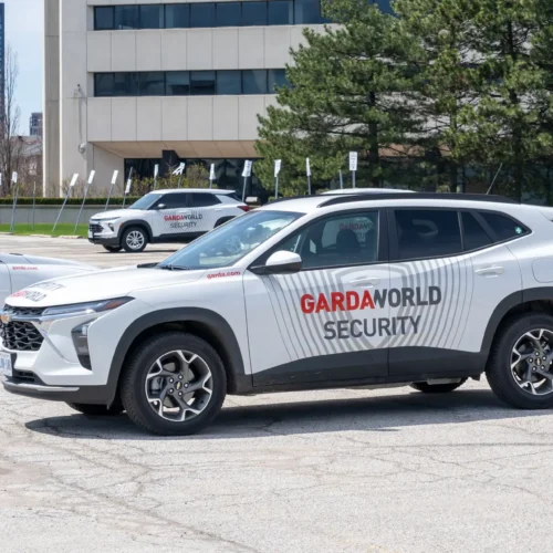 Weisser  Sicherheits  SUV  ohne  Personen  mit  GARDAWORLD  Schriftzug  und  Streifen